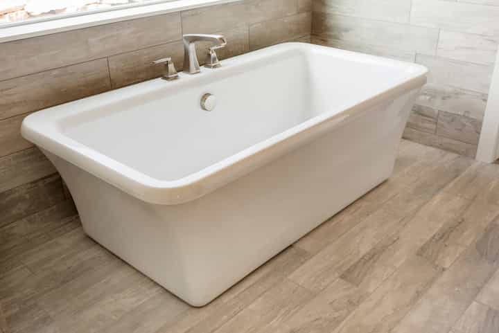 Luxury soaking bathtub installation in Boulder, Colorado condo brings an all-white setting